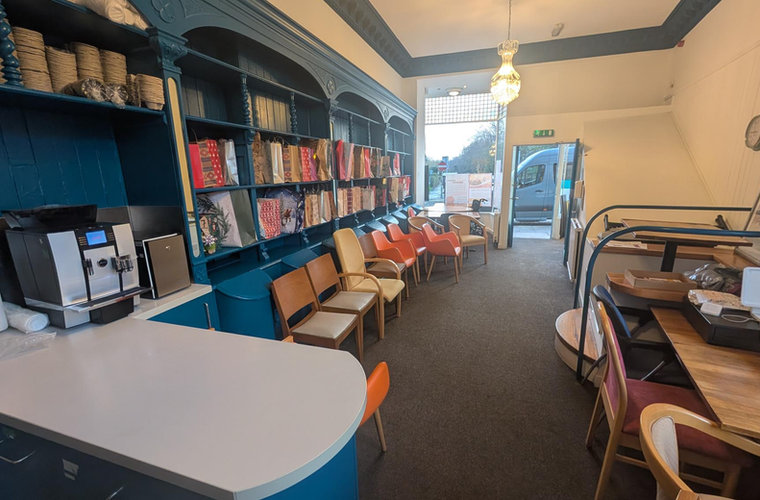 The characterful café room at The Open Door with its blue dresser and warm lighting.